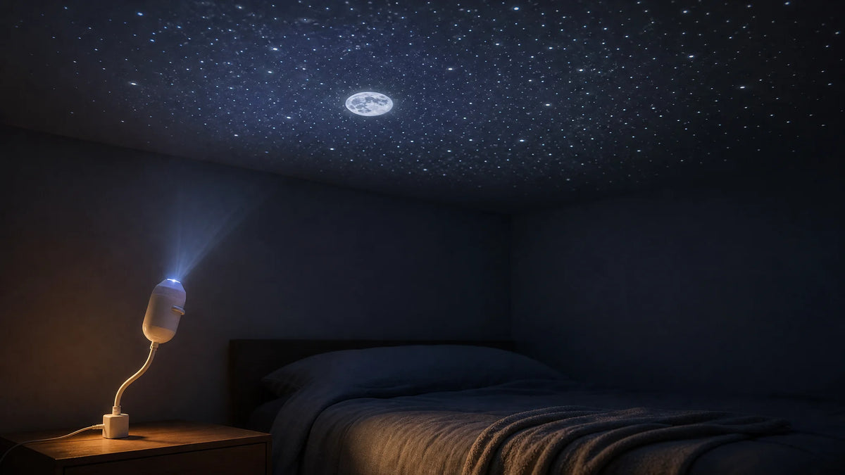 Small USB star projector on a bedside table casting a starry sky and moon across a dark bedroom ceiling